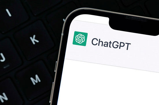 A cellphone screen shows the words ChatGPT, along with a logo
